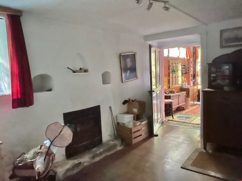 living room with fireplace, white walls, rug, storage boxes, painting, table