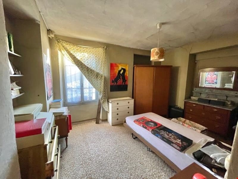 Large bedroom, white walls, carpeted floor, windows, bed, dresser, cabinet, bookshelf, lamp, painting