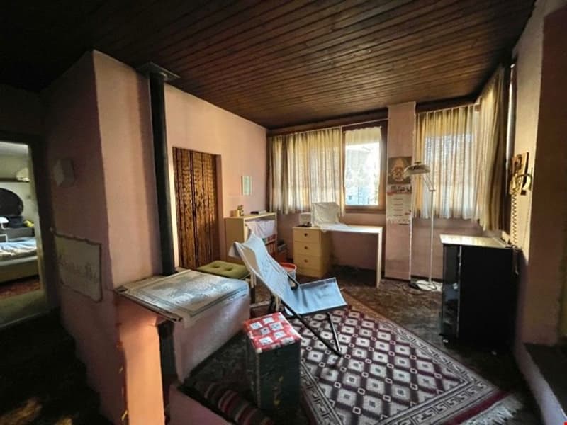 Small room with a desk, chair, carpet, storage boxes, and a lamp