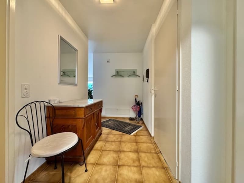 Corridor with chair, cupboard, mirror, entrance door, power outlet, umbrellas