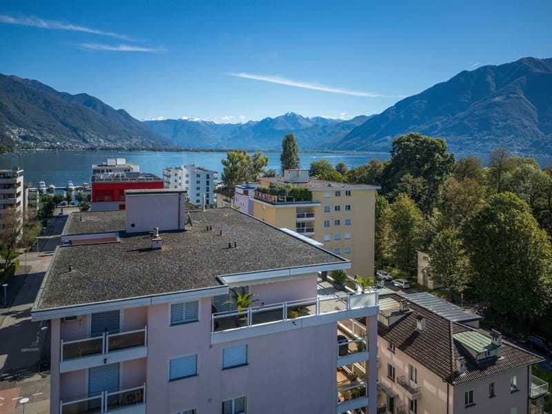 Mountains, a city, and a lake with buildings visible in the foreground.