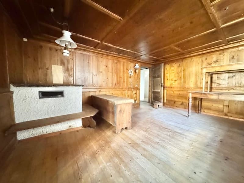 Rustic wooden interior with exposed beams, wooden floors, and a fireplace