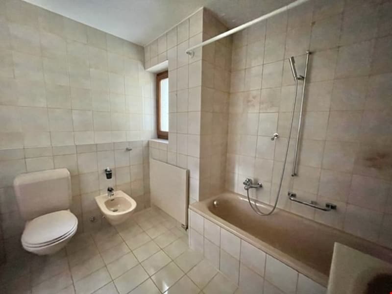 tiled floor, toilet, bidet, bathtub, shower, radiator, window