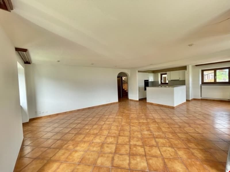 large open space, tiled floor, white walls, kitchen area, staircase, windows
