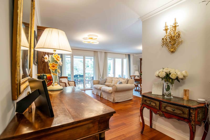 living room with white couches, table, decorative vase, balcony