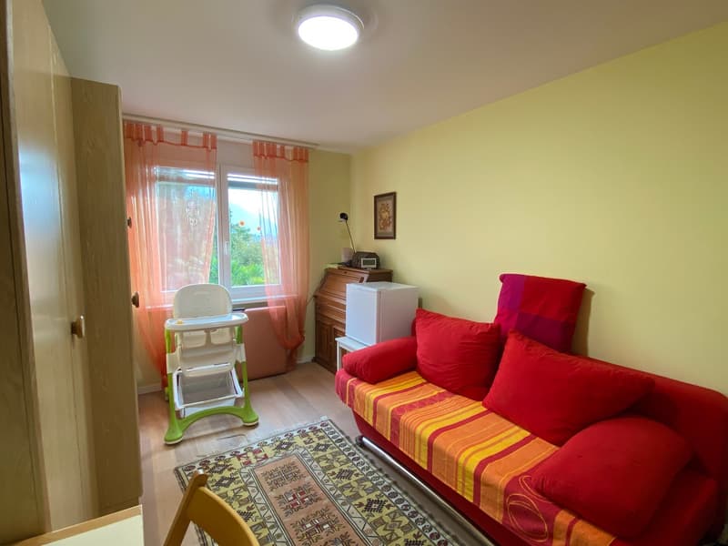 Living room: sofa, desk, cabinet, window, lamp, rug, mini fridge, framed picture, armchair