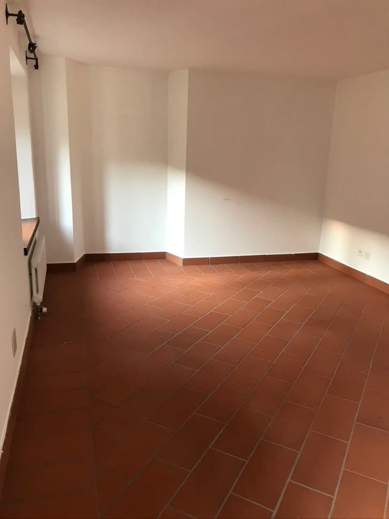empty room, red tile flooring, white walls, heater, window