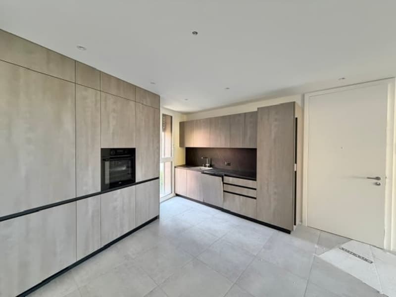 modern kitchen with built-in cabinets, white tiled floor, black oven, sink, faucet, window