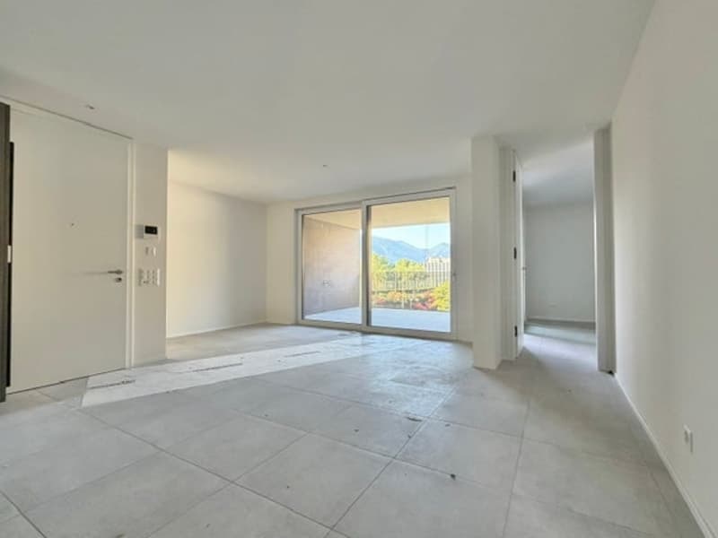Empty room with sliding glass door, balcony, white walls, tiled floor