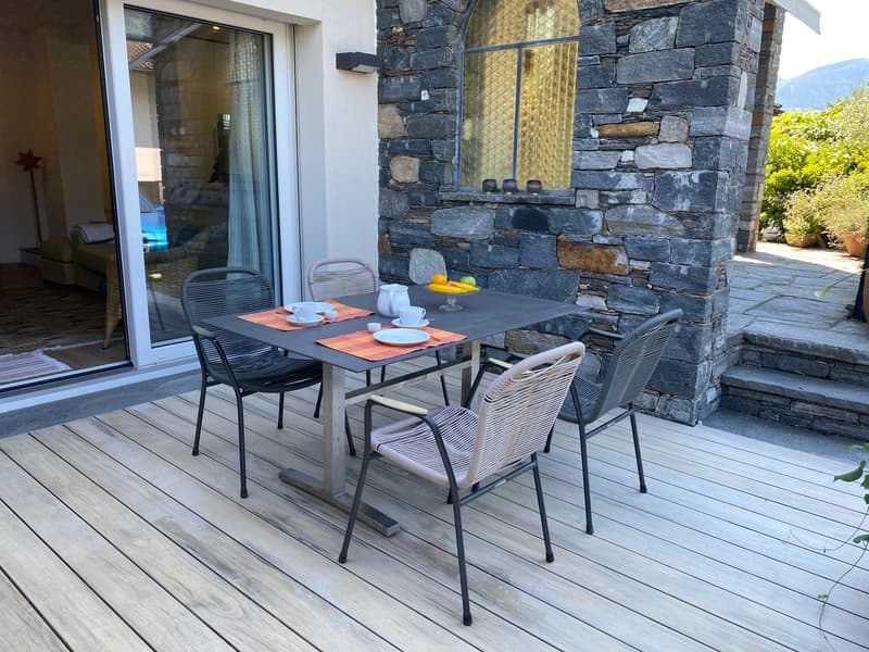 outdoor dining area with a table, chairs, and fruit tray
