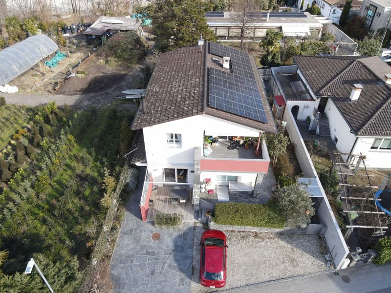 two story house, white exterior, solar panels on roof, wooden deck, swimming pool, red car