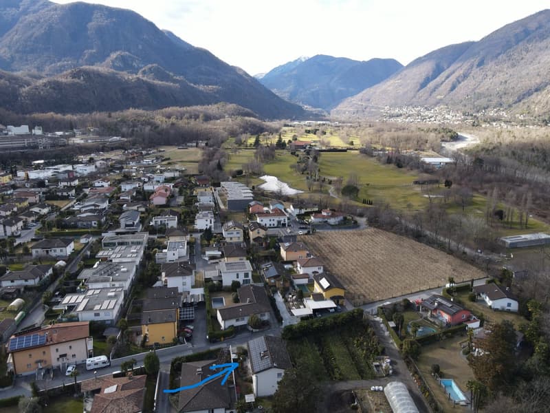 Many houses, mountains, clear sky, vegetation, swimming pool, solar panels