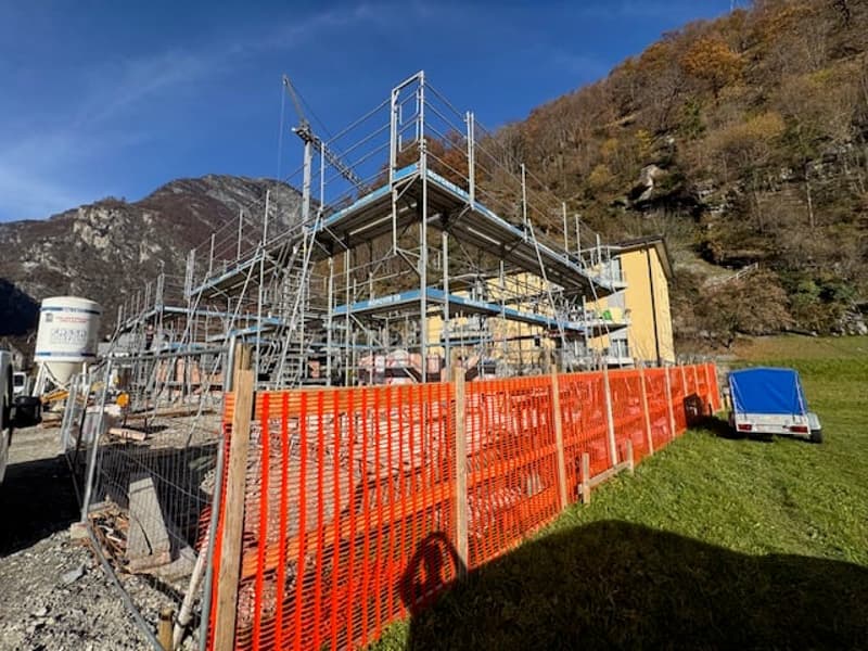 construction site of a house with mountains in the background