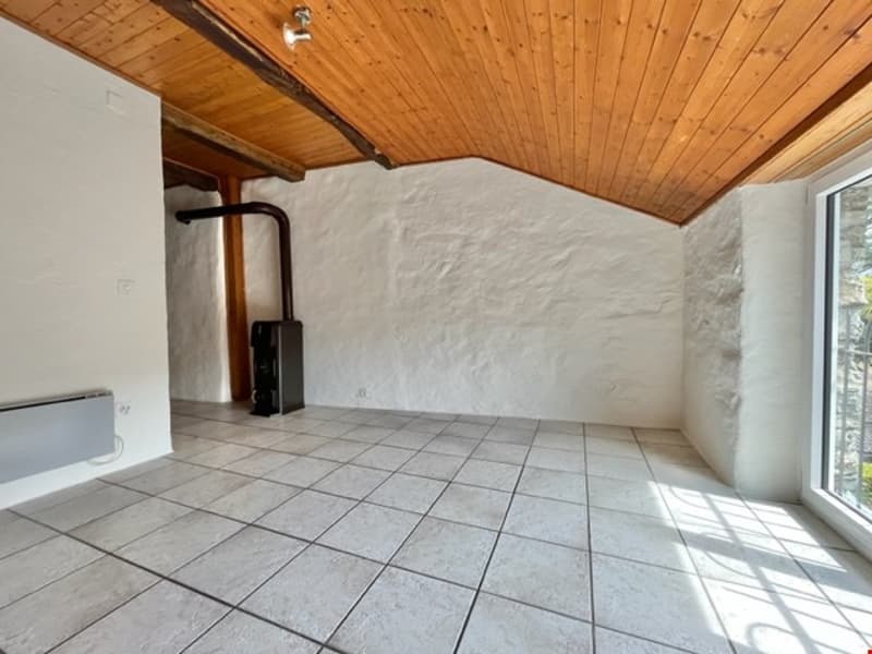 empty room with tiled floor, wooden ceiling, white wall, window, radiator