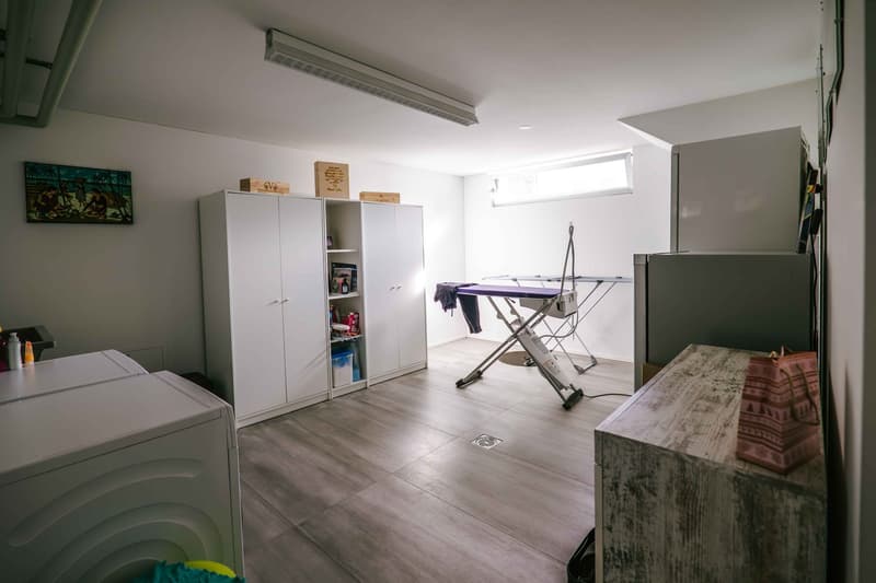 laundry room with washing machine, dryer, ironing table, shelves, and storage boxes