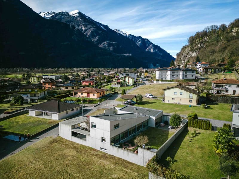 A modern architectural building with angular design, situated in a rural area with panoramic mountain views
