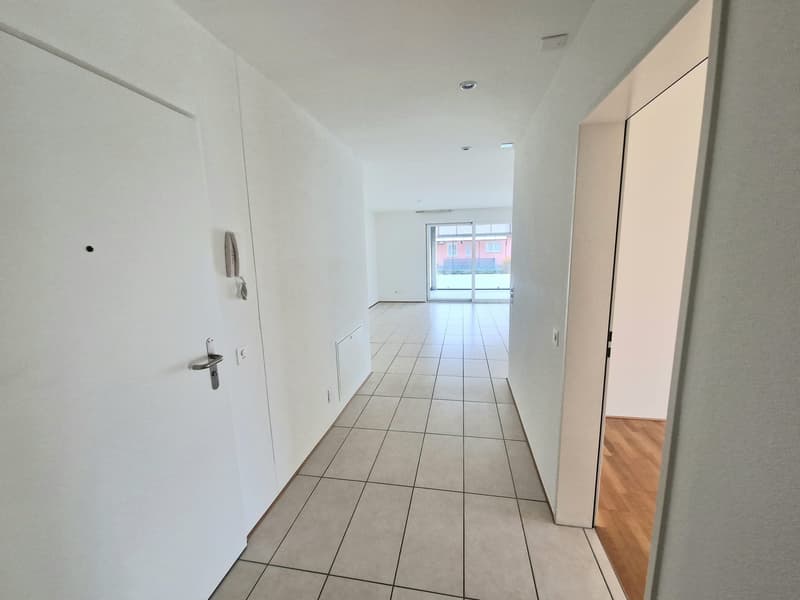 white walls, tiled floor, no furniture, hallway