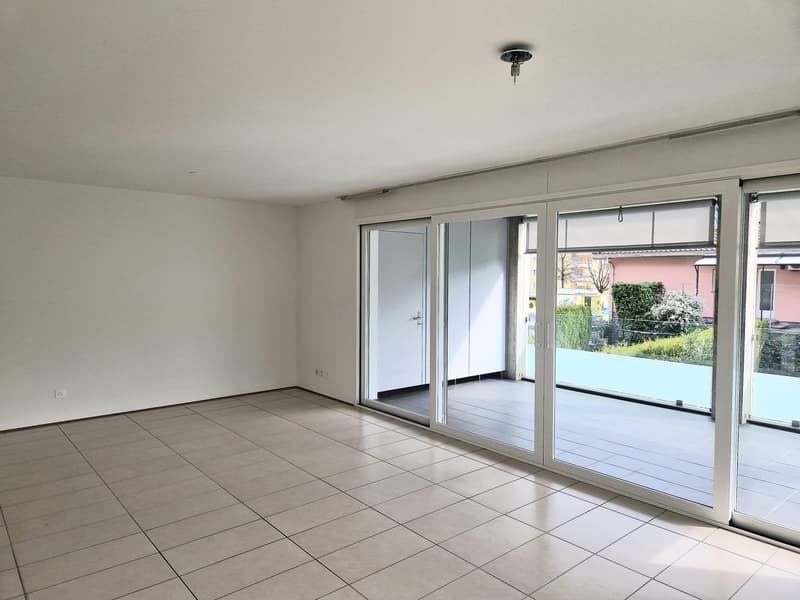 empty room, white walls, white tile floor, sliding glass doors, balcony