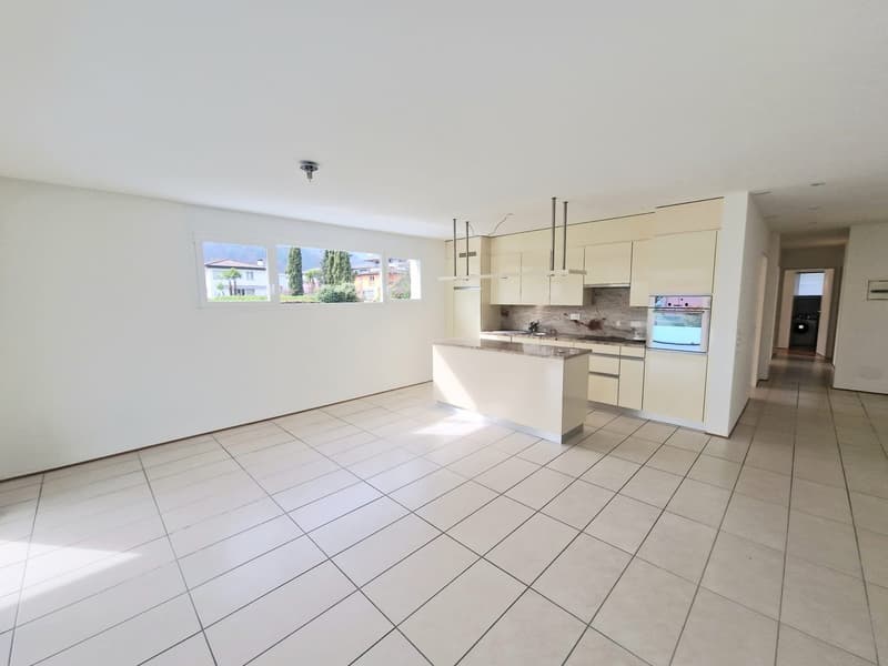 modern kitchen with white tiles, white cabinets, granite countertop, built-in oven, dishwasher, island with sink