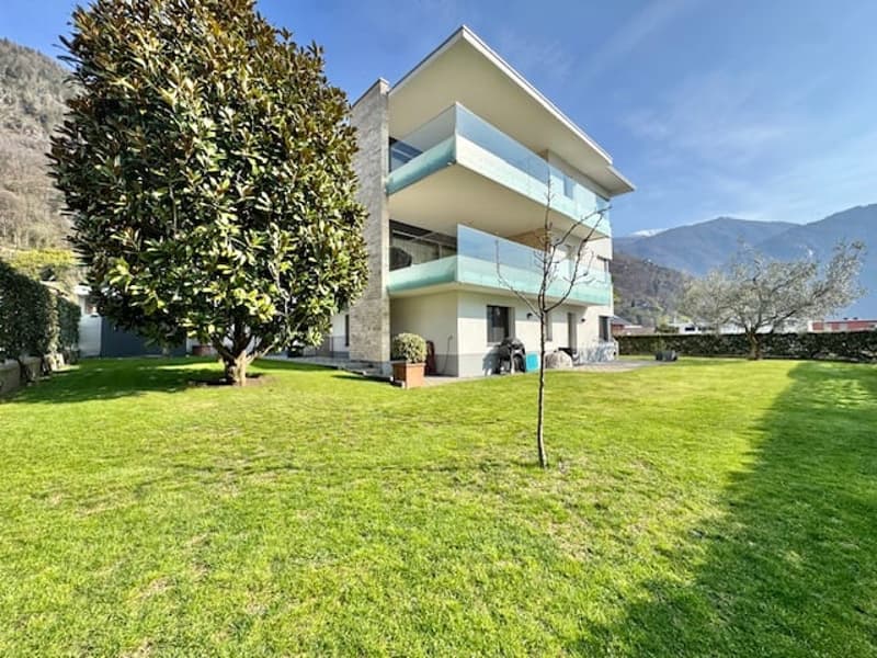 Modern house, 2 floors, large windows, balconies, green lawn, trees, mountains in the background