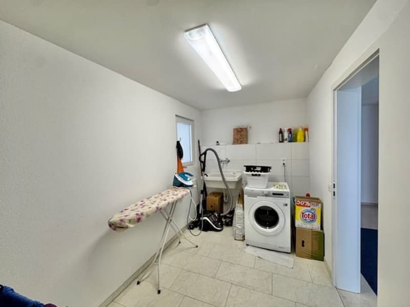 Laundry room with washing machine, iron, sink, and storage boxes