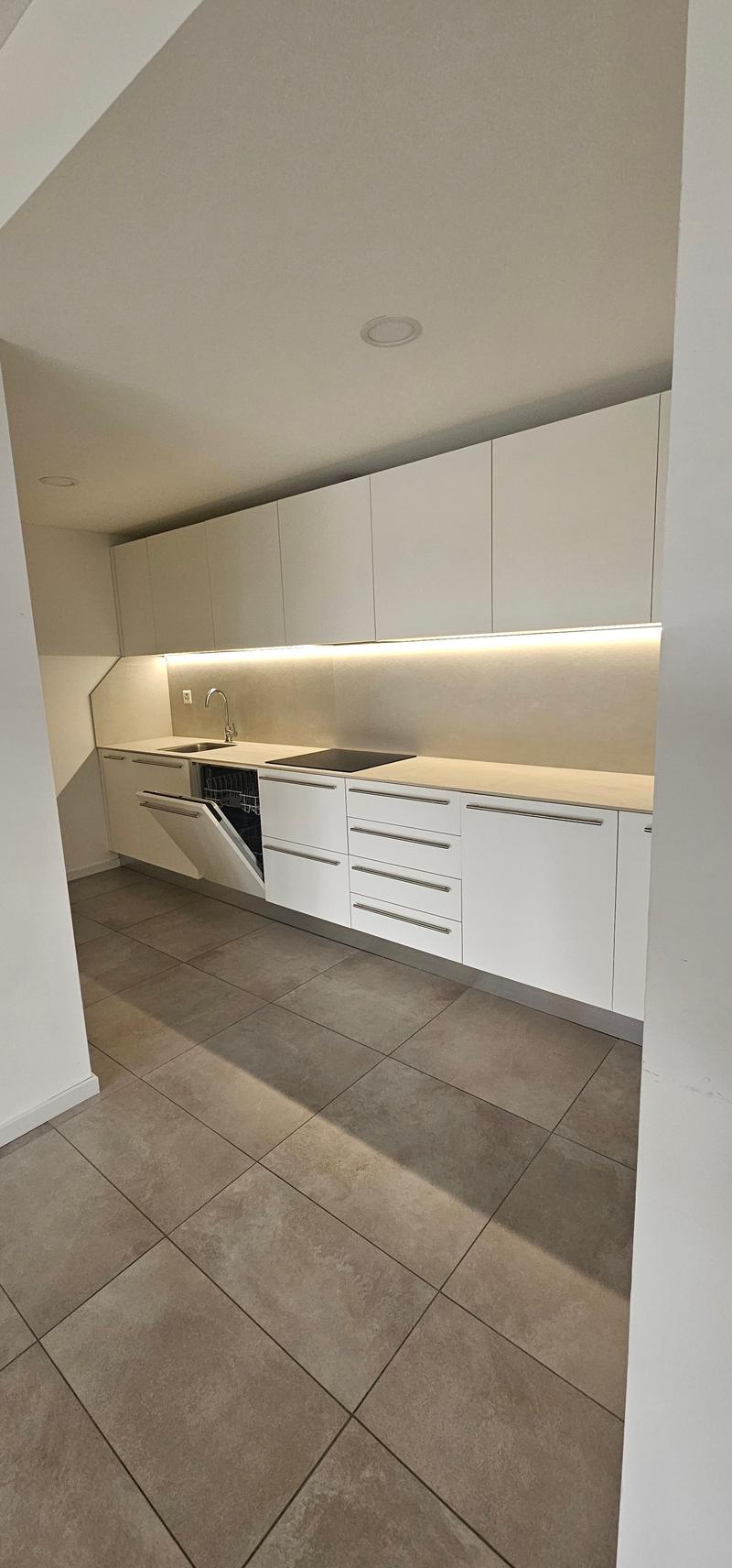 modern kitchen with white cabinets, built-in dishwasher, tiled flooring, LED under cabinet lighting, stainless steel appliances, granite countertops