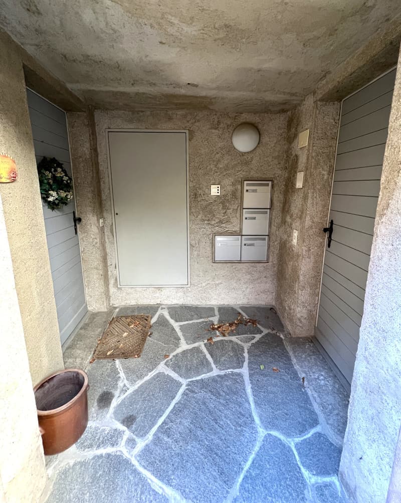 stone floor, two doors, mailbox, light fixture, wreath