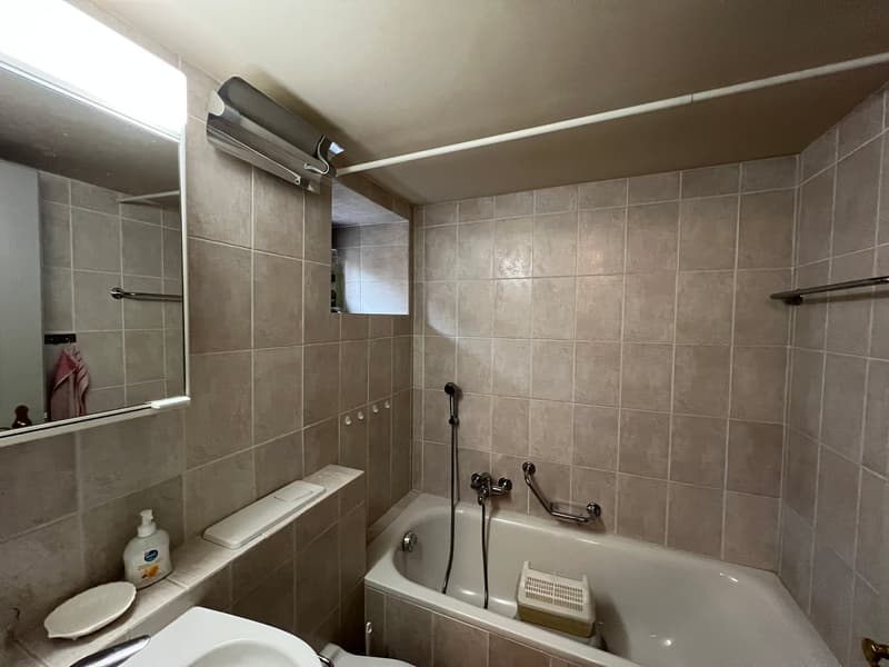 Bathroom with bathtub, sink, mirror, and toilet