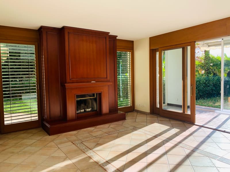 living room with fireplace, glass walls, wooden flooring