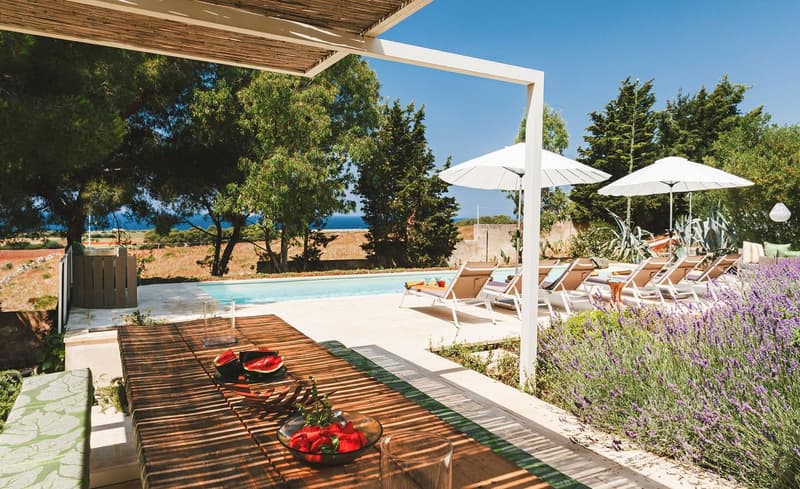 Outdoor dining table with umbrellas, swimming pool, lounge chairs, lavender plants, ocean view