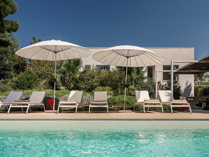 Outdoor area with a swimming pool, lounge chairs, and umbrellas