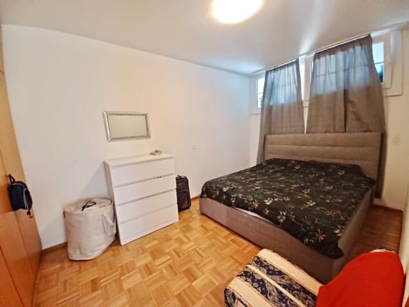 single bed, bed sheets, nightstand, lamp, mirror, cabinet, armchair, trash can, backpack, luggage