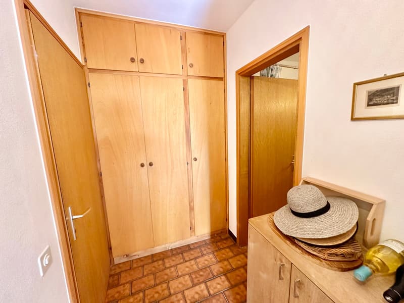 wooden cabinets, tiled floor, open door, hat, bottle