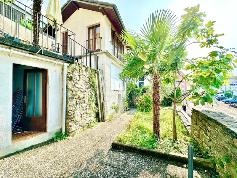 Stone wall, balcony, open door, palm tree, gravel path, stone wall