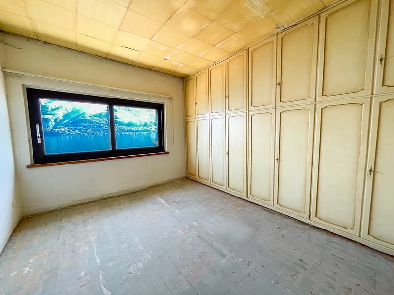 empty room, single window, wooden floor, multiple white wardrobes, yellow walls