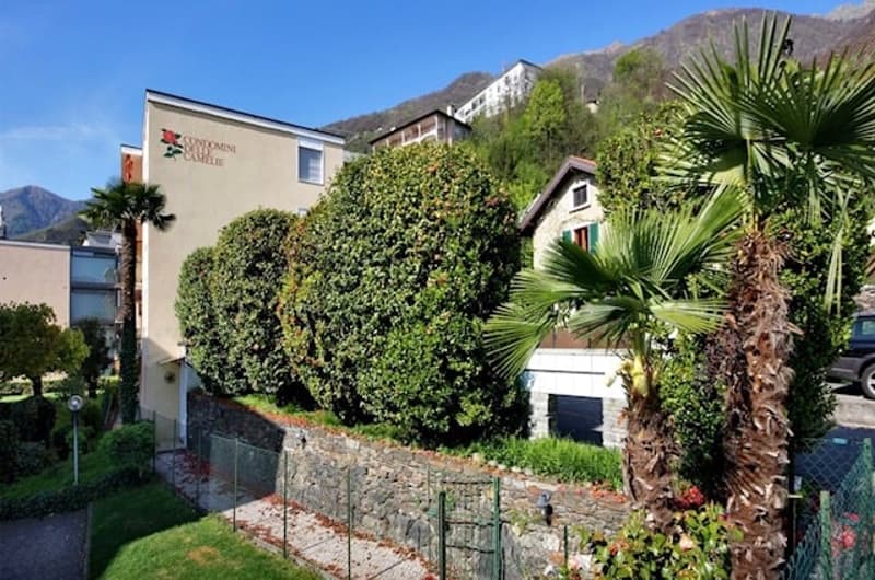 exterior of apartment building with a garden, mountains in the background