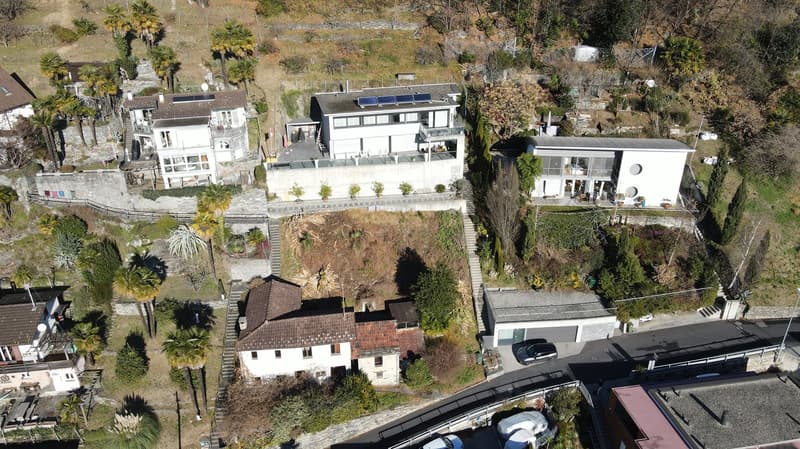 Aerial view, 5 houses, solar panels on roofs, trees and plants, garage, driveway, road