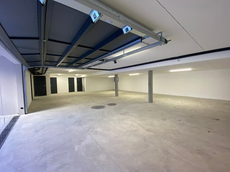 Empty garage with concrete floor, metal ceiling, and three closed doors