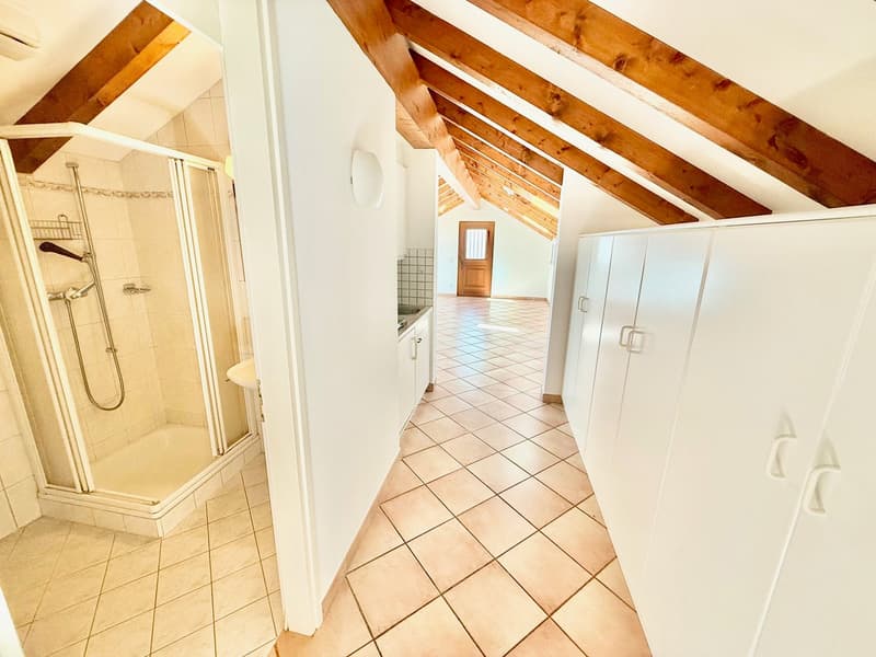 Walk-in shower, tiled floor, vanity, wooden beams, white cabinets