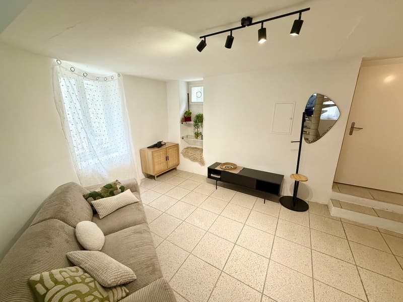 living room with couch, coffee table, wooden cabinet, stairs, white walls, white tile flooring, track lighting, curtain, round mirror