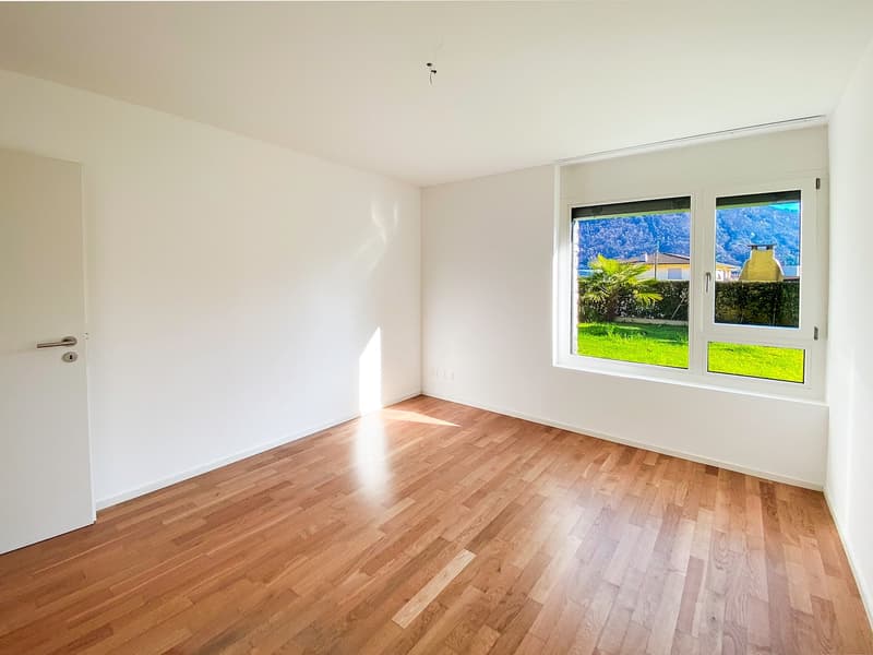 empty room, wooden floor, white walls, large window with view of mountains