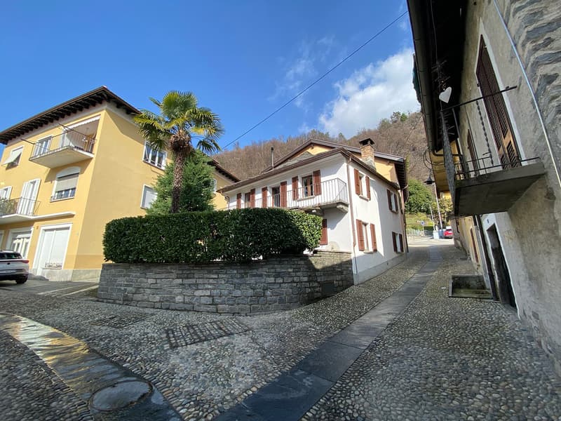 cobblestone street, stone retaining wall, tall yellow and white buildings, balconies