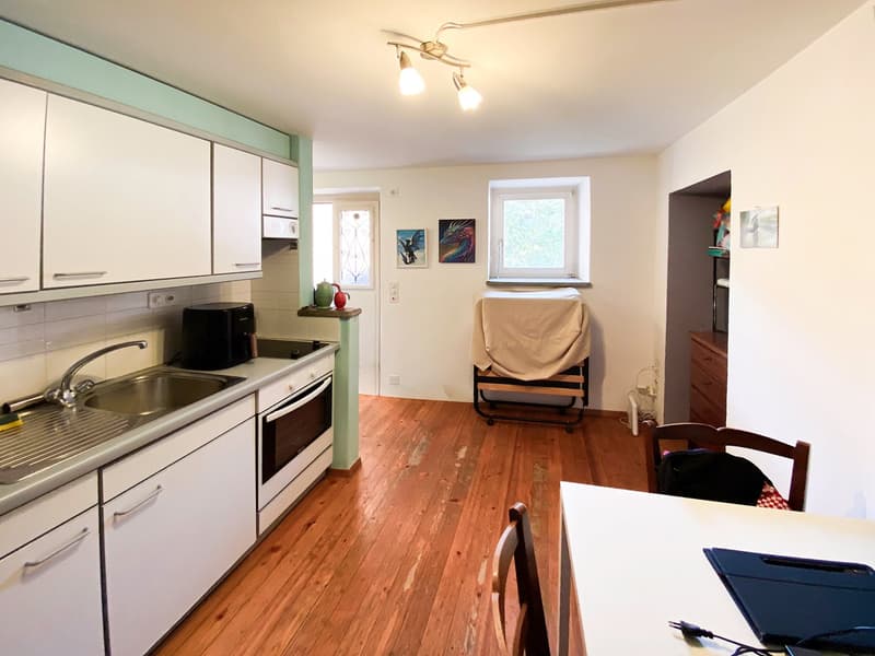 kitchen, wooden floor, white cabinets, sink, oven, window, lamps