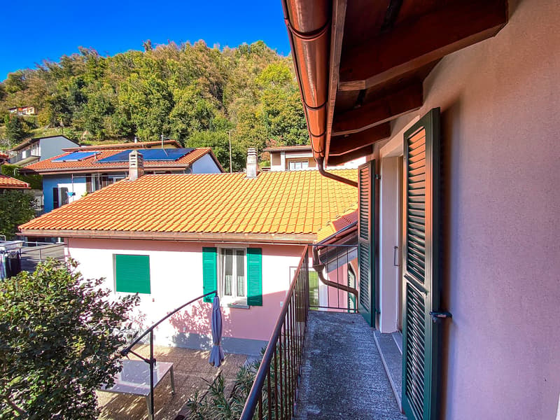 terraced house, orange roof, pink facade, green shutters, metal balcony railing