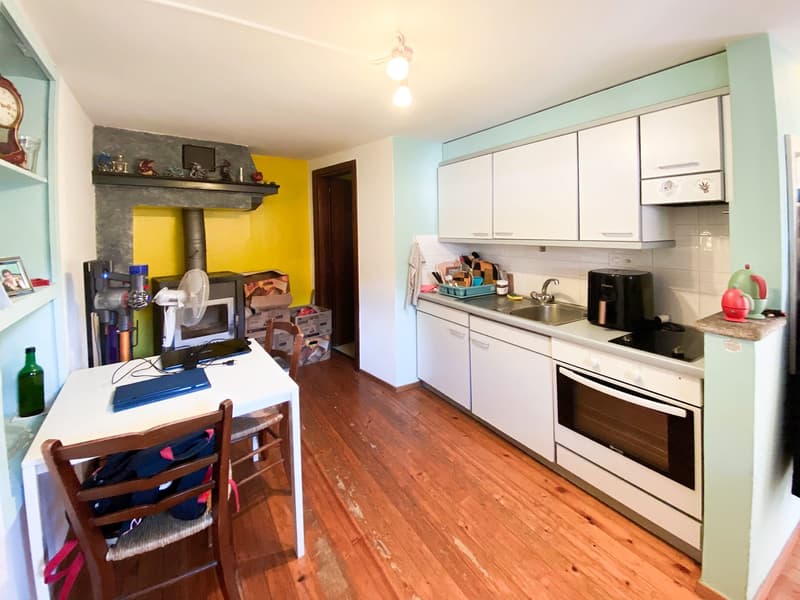 white cabinets, oven, dishwasher, refrigerator, sink, faucet, table with laptop, fireplace, kitchen fan, clock