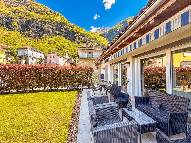 A building with a terrace, garden, and scenic view of mountains and houses