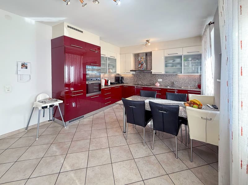 modern kitchen with red and white cabinet, electric oven, dishwaher, dishwasher, dining area with 4 chair and 1 table