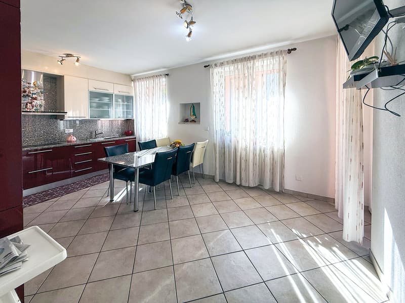 kitchen area with cabinets, dining table, dining chairs, open living area with curtains