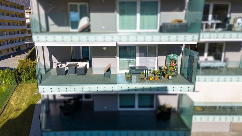 balcony, lounge chairs, table, plants, glass railing, lower level balcony, grass