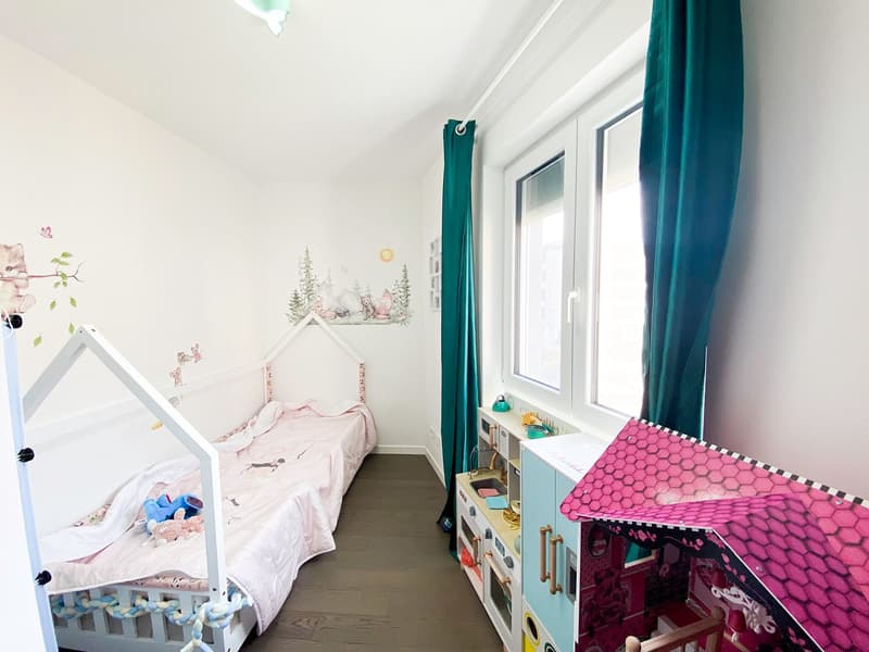 white walls, wooden bed, white bedsheets, blue stuffed toys, children toys, curtains, wall decals